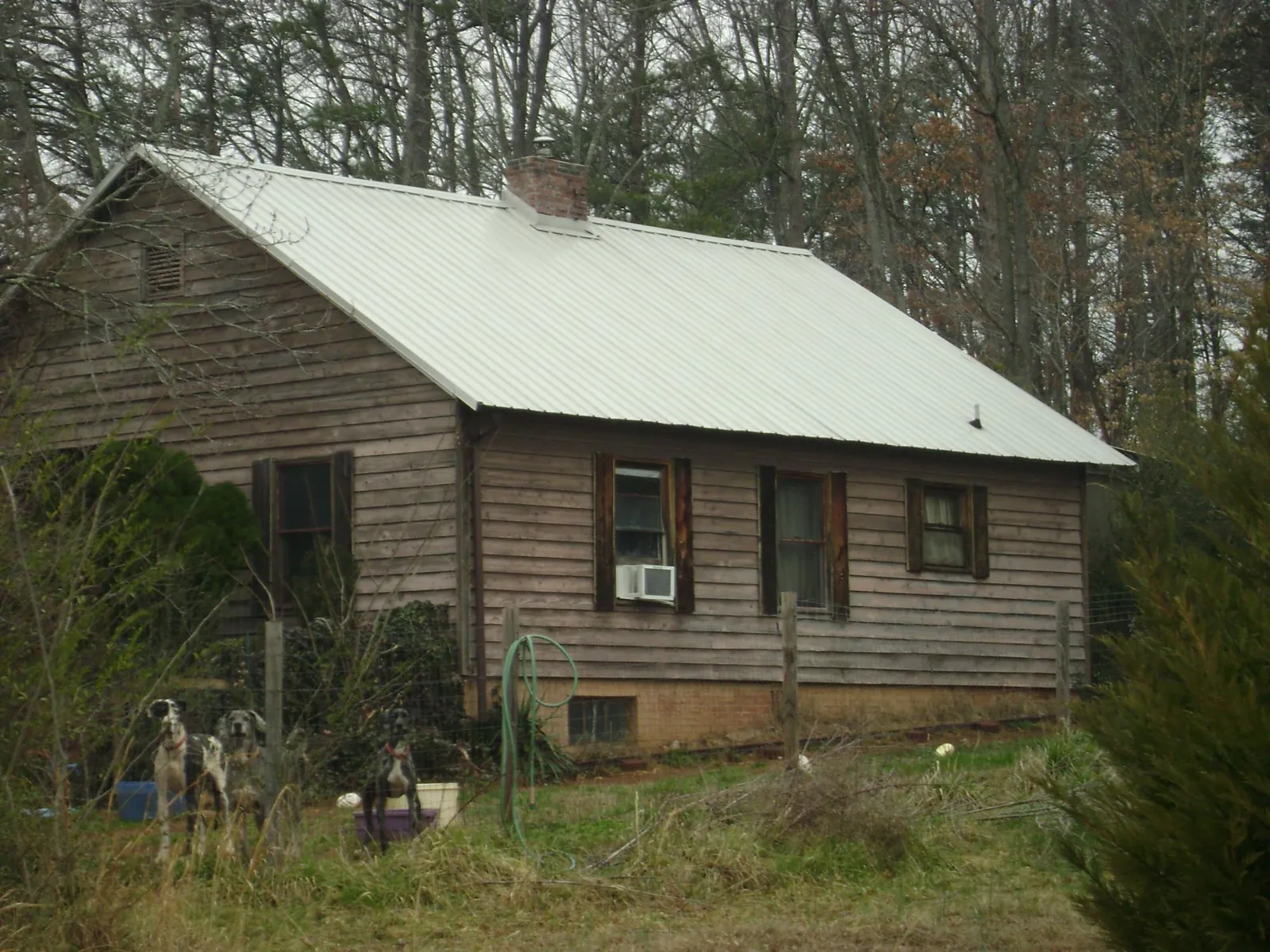 White metal roof on an old wood sided farmhouse, from a Metal Roof Installation job in Holden
